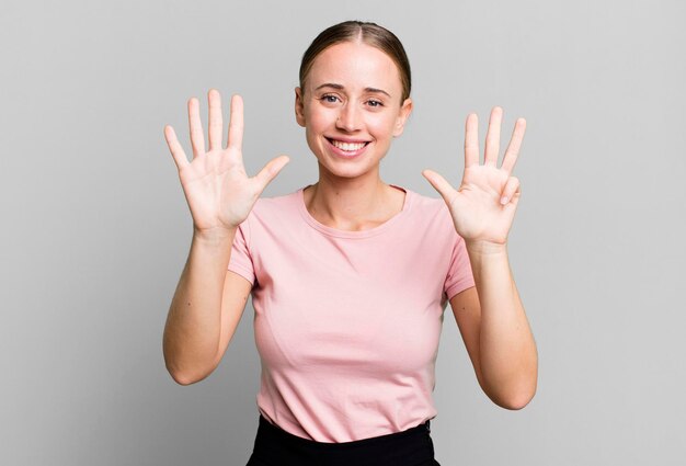 Sorridendo e guardando amichevole che mostra il numero nove o nono con il conto alla rovescia della mano in avanti