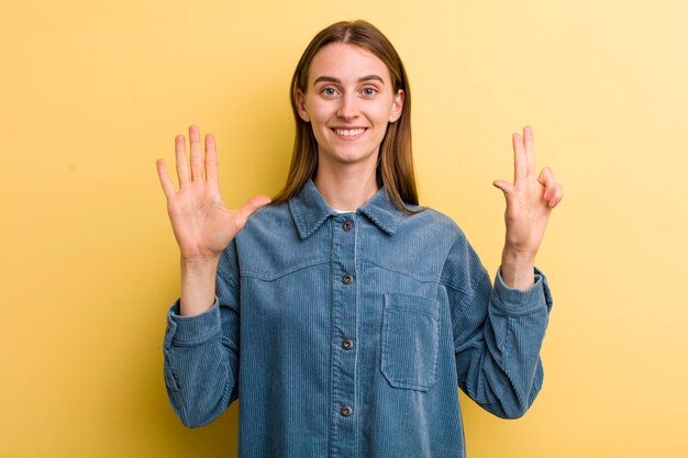 Sorridendo e guardando amichevole che mostra il numero otto o ottavo con il conto alla rovescia della mano in avanti