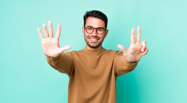 Sorridendo e guardando amichevole che mostra il numero otto o ottavo con il conto alla rovescia della mano in avanti