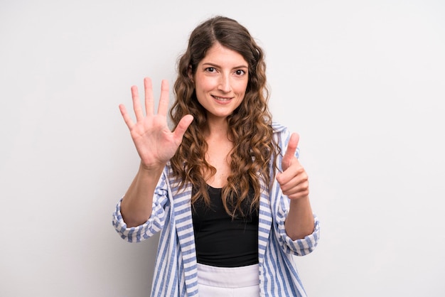 Sorridendo e guardando amichevole che mostra il numero sei o sesto con il conto alla rovescia della mano in avanti