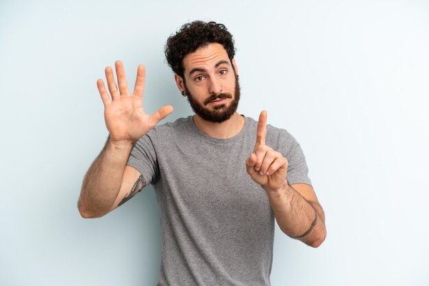 Sorridendo e guardando amichevole che mostra il numero sei o sesto con il conto alla rovescia della mano in avanti