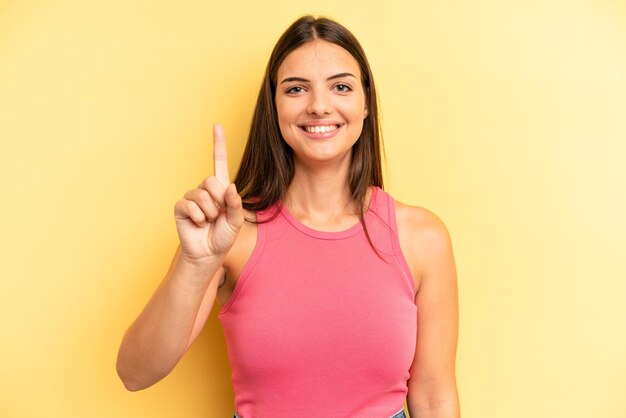 sorridendo e guardando amichevole che mostra il numero uno o il primo con il conto alla rovescia in avanti