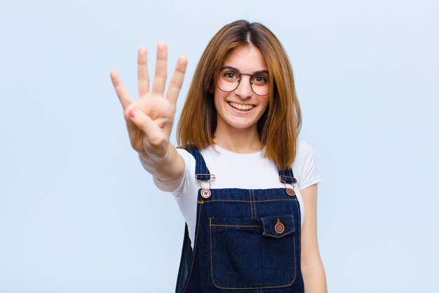 sorridendo e guardando amichevole, mostrando il numero quattro o il quarto con la mano in avanti, conto alla rovescia