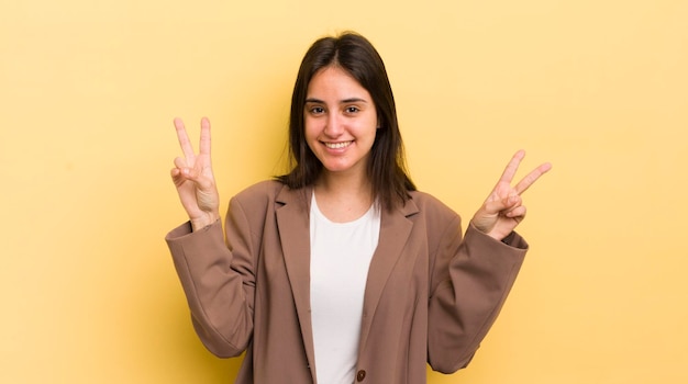 Sorridendo e guardando felice, amichevole e soddisfatto, gesticolando vittoria o pace con entrambe le mani