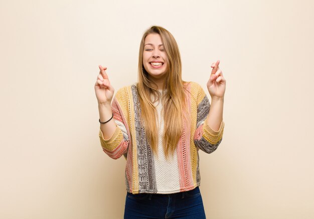 sorridendo e incrociando ansiosamente entrambe le dita, sentendosi preoccupato e desiderando o sperando in buona fortuna