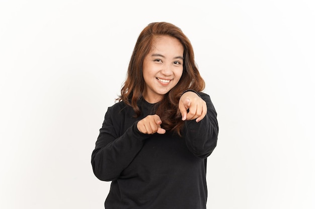 Sorridendo e indicandoti di una bella donna asiatica che indossa una camicia nera isolata su bianco