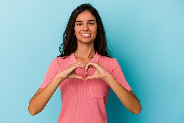 Sorridendo e mostrando una forma di cuore con le mani