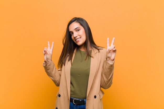 sorridendo e sembrando felice, amichevole e soddisfatto, gesticolando vittoria o pace con entrambe le mani