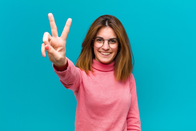 sorridendo e sembrando felice, spensierato e positivo, gesticolando vittoria o pace con una mano