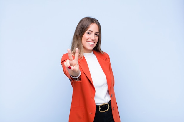 sorridendo e sembrando felice, spensierato e positivo, gesticolando vittoria o pace con una mano