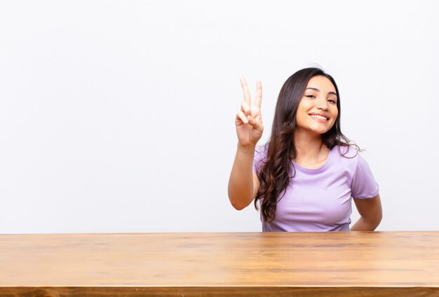 sorridendo e sembrando felice, spensierato e positivo, gesticolando vittoria o pace con una mano