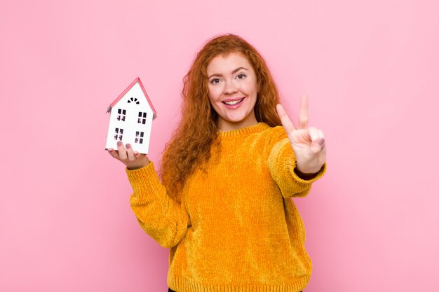 sorridendo e sembrando felice, spensierato e positivo, gesticolando vittoria o pace con una mano