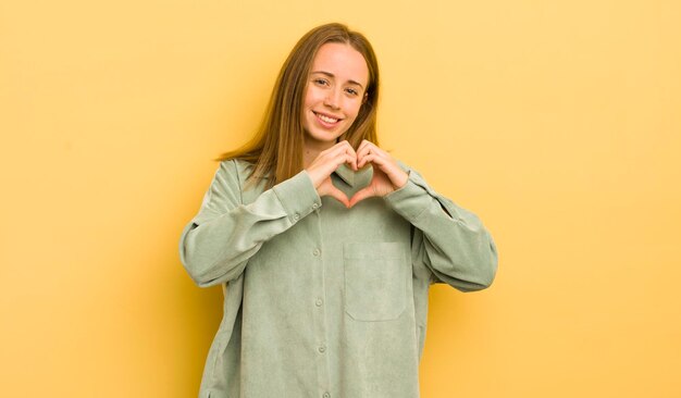 sorridendo e sentendosi felice carino romantico e innamorato a forma di cuore con entrambe le mani