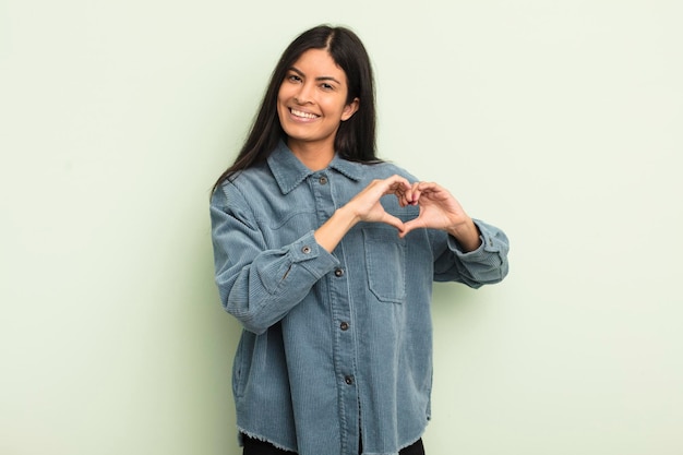 sorridendo e sentendosi felice carino romantico e innamorato a forma di cuore con entrambe le mani