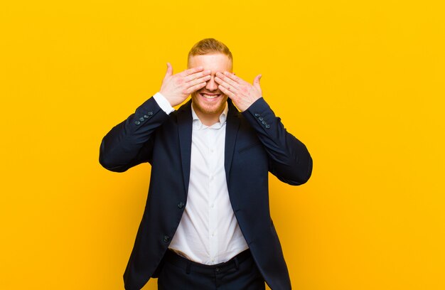 sorridendo e sentendosi felice, coprendo gli occhi con entrambe le mani e aspettando un'incredibile sorpresa