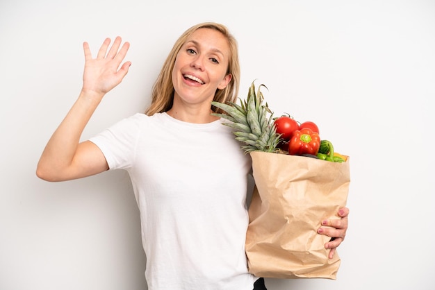 Sorridendo felicemente agitando la mano accogliendoti e salutandoti