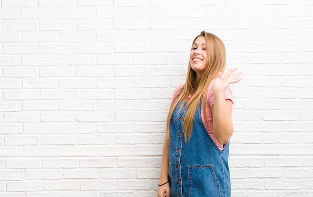 sorridendo felicemente e allegramente, agitando la mano, dandoti il benvenuto e salutandoti, o salutandoti