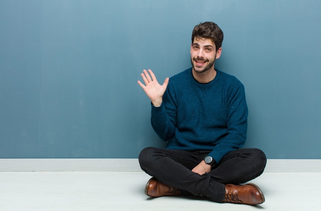 sorridendo felicemente e allegramente, agitando la mano, dandoti il benvenuto e salutandoti, o salutandoti