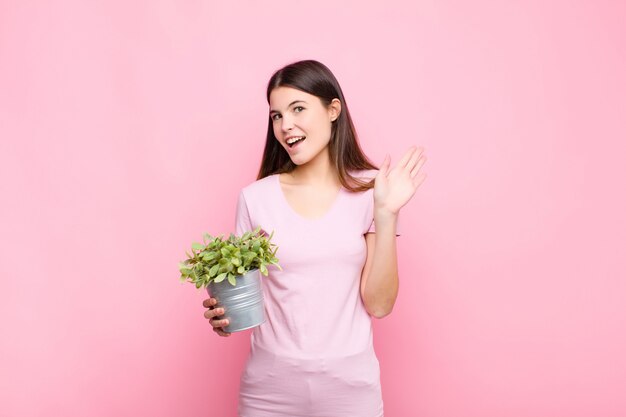 sorridendo felicemente e allegramente, agitando la mano, dandoti il benvenuto e salutandoti