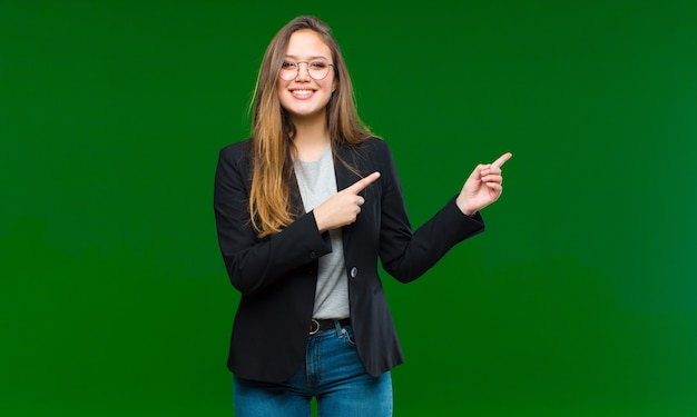 sorridendo felicemente e indicando il lato e verso l'alto con entrambe le mani che mostrano l'oggetto