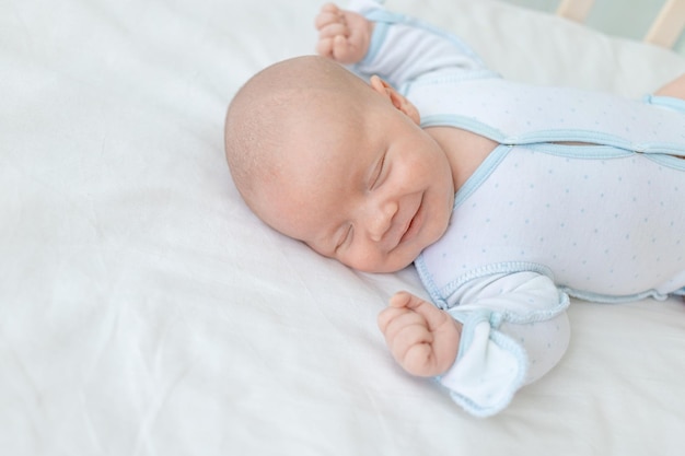 Sorridendo o ridendo in un sogno, un neonato dorme per sette giorni in una culla a casa su un letto di cotone in primo piano