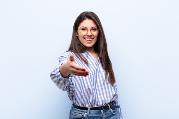 sorridendo, sembrando felice, fiducioso e amichevole, offrendo una stretta di mano per chiudere un affare, collaborando