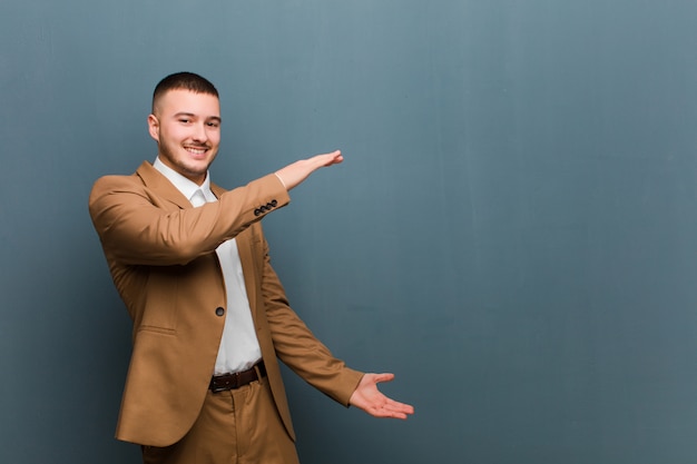 sorridendo, sentendosi felice, positivo e soddisfatto, tenendo o mostrando oggetto o concetto sullo spazio della copia