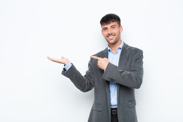 sorridendo, sentendosi felice, spensierato e soddisfatto, indicando il concetto o l'idea sullo spazio della copia sul lato