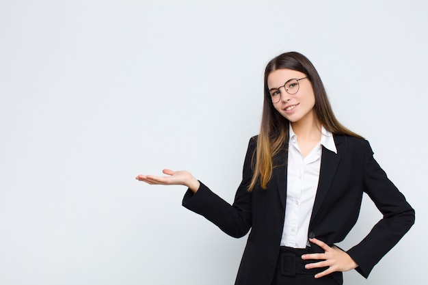 sorridendo, sentendosi sicuro, riuscito e felice, mostrando il concetto o l'idea sullo spazio della copia dal lato