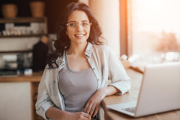 Sorridente amante del caffè con il computer portatile nella caffetteria