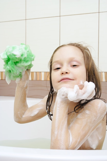 Sorridente bambino coperto di sapone al bagno