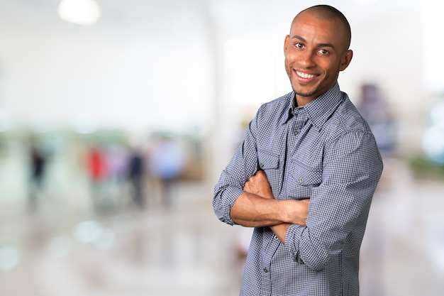 Sorridente bell'uomo con le mani incrociate sullo sfondo