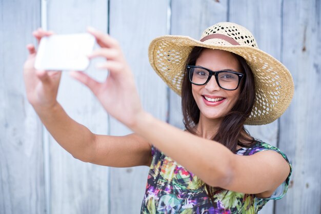 Sorridente bella bruna prendendo selfie