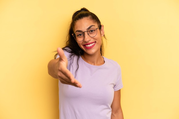 sorridente che sembra felice fiducioso e amichevole offrendo una stretta di mano per concludere un affare collaborando