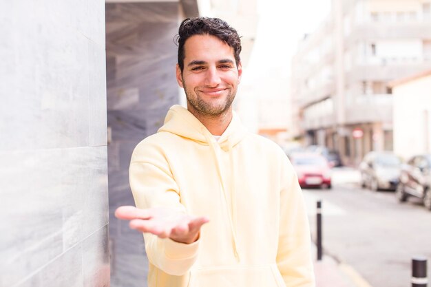 sorridente che sembra felice fiducioso e amichevole offrendo una stretta di mano per concludere un affare collaborando