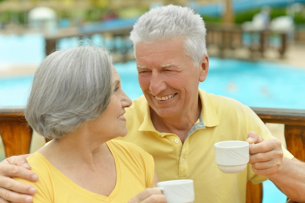 Sorridente coppia senior che beve caffè su sfondo sfocato