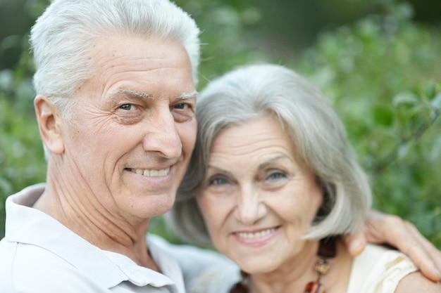 Sorridente coppia senior che si abbraccia nel parco autunnale