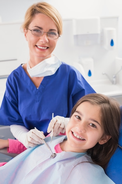 Sorridente dentista pediatrico con un giovane paziente felice