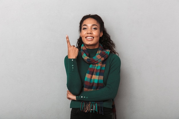 Sorridente donna africana che indossa un maglione che punta