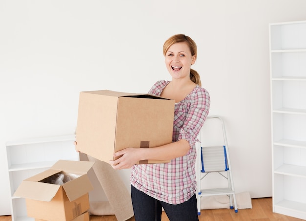 Sorridente donna che trasportano scatole di cartone