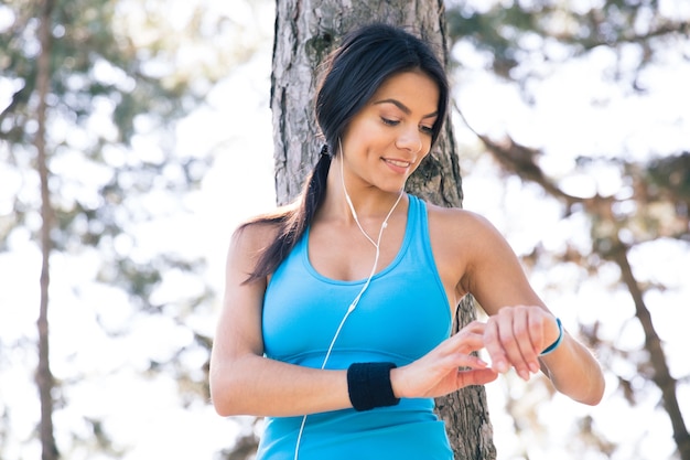 Sorridente donna sportiva utilizzando smart watch