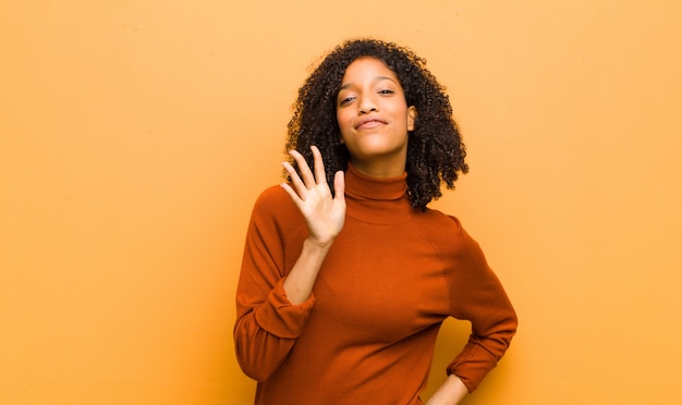 sorridente e amichevole, mostrando il numero cinque o il quinto con la mano in avanti, il conto alla rovescia