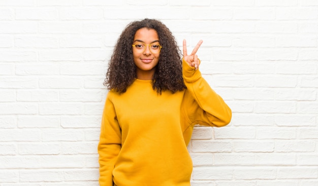 sorridente e amichevole, mostrando il numero due o il secondo con la mano in avanti, il conto alla rovescia