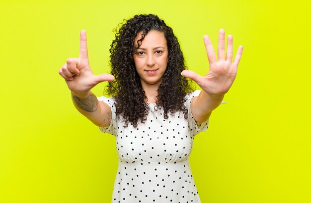 sorridente e amichevole, mostrando il numero sette o il settimo con la mano in avanti, il conto alla rovescia