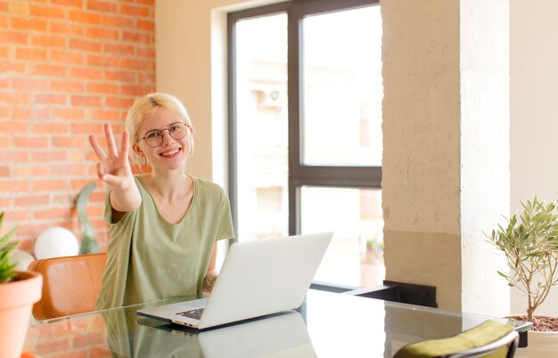 sorridente e donna che sembra amichevole, mostrando il numero tre o il terzo con la mano in avanti, conto alla rovescia