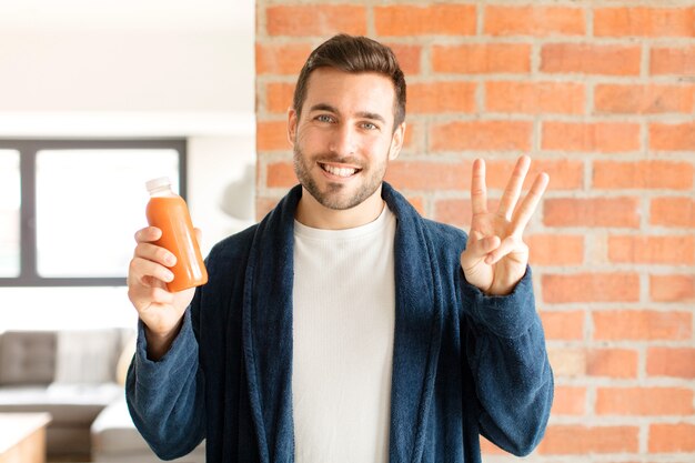 sorridente e uomo che sembra amichevole, mostrando il numero tre o il terzo con la mano in avanti, conto alla rovescia