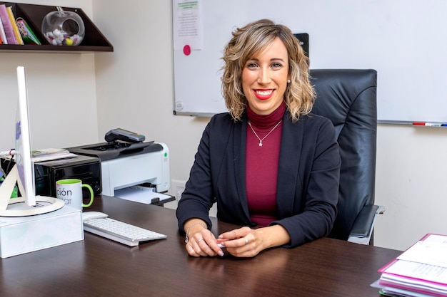 Sorridente giovane adulto elegante leader professionale donna d'affari femminile manager esecutivo donna d'affari che indossa tuta in piedi guardando il ritratto della fotocamera