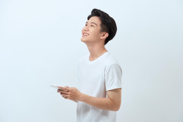 Sorridente giovane bell'uomo asiatico che utilizza smartphone
