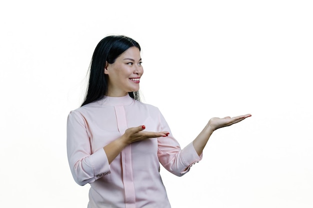 Sorridente giovane donna asiatica allegra che mostra lo spazio della copia con entrambe le mani isolato su sfondo bianco