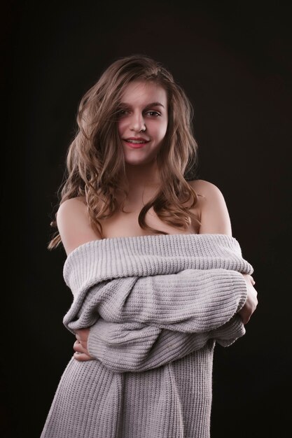 Sorridente giovane donna con le spalle nude in posa in studio